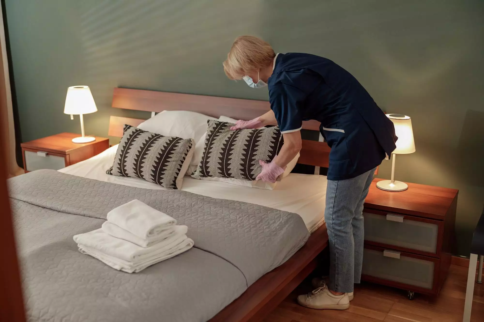 Cleaning lady doing housekeeping and making bed in hotel room. Cleaning service concept